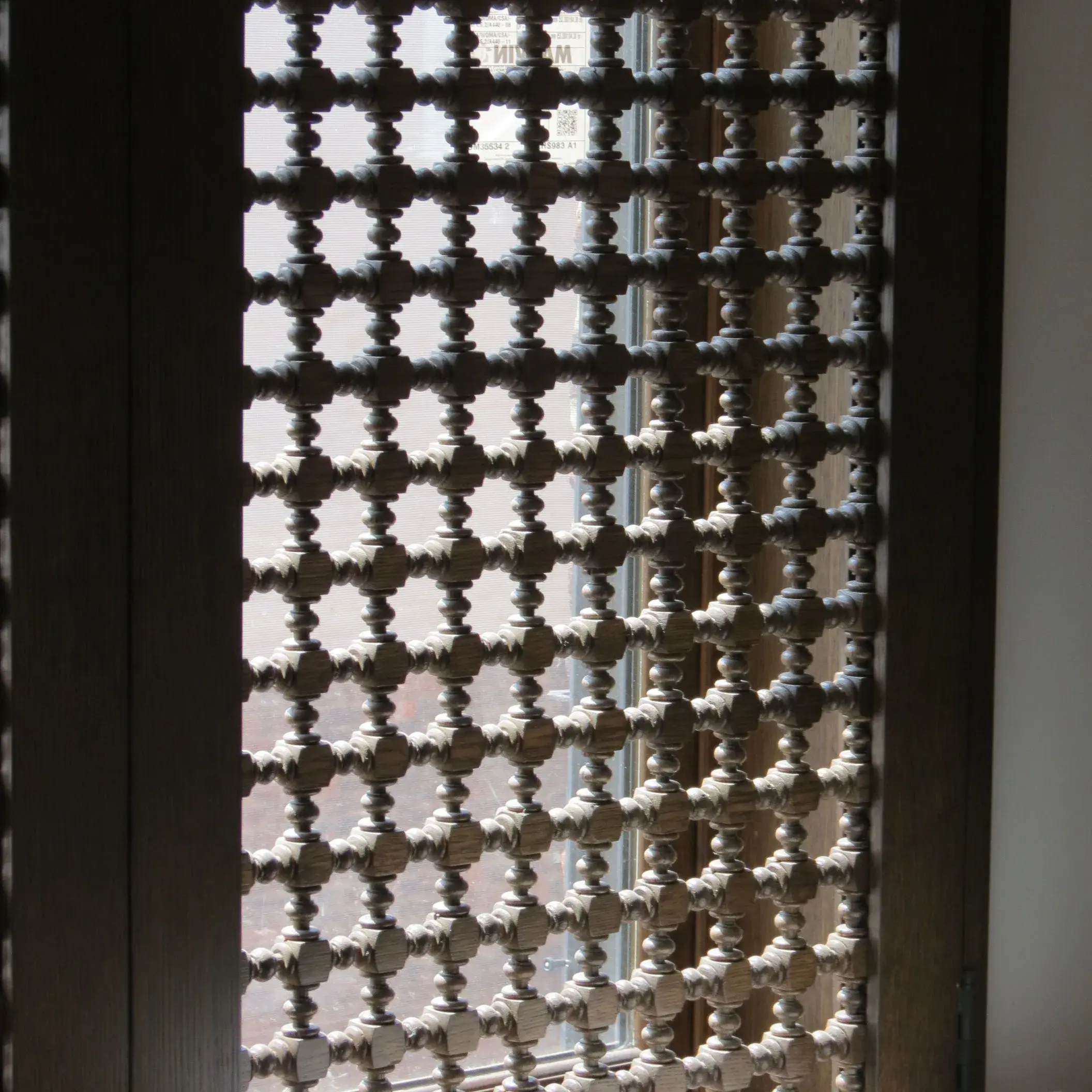 Carved geometric wooden screen with light passing through